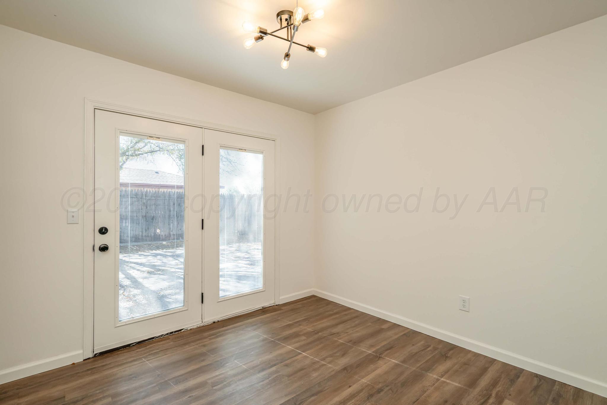 3206 Wind Song Drive Amarillo, TX 79103 - Photo 11 of 27 an empty room with wooden floor and windows