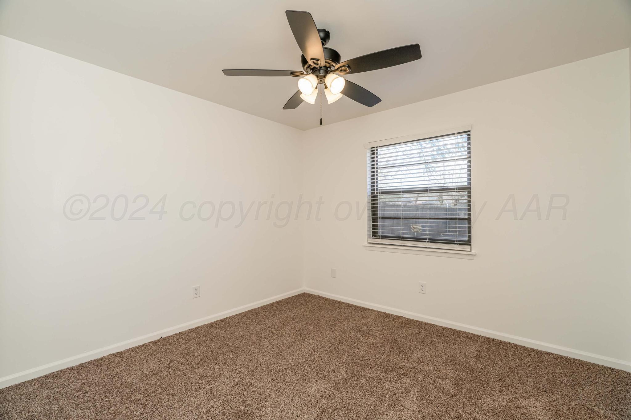 3206 Wind Song Drive Amarillo, TX 79103 - Photo 13 of 27 an empty room with a window and a fan