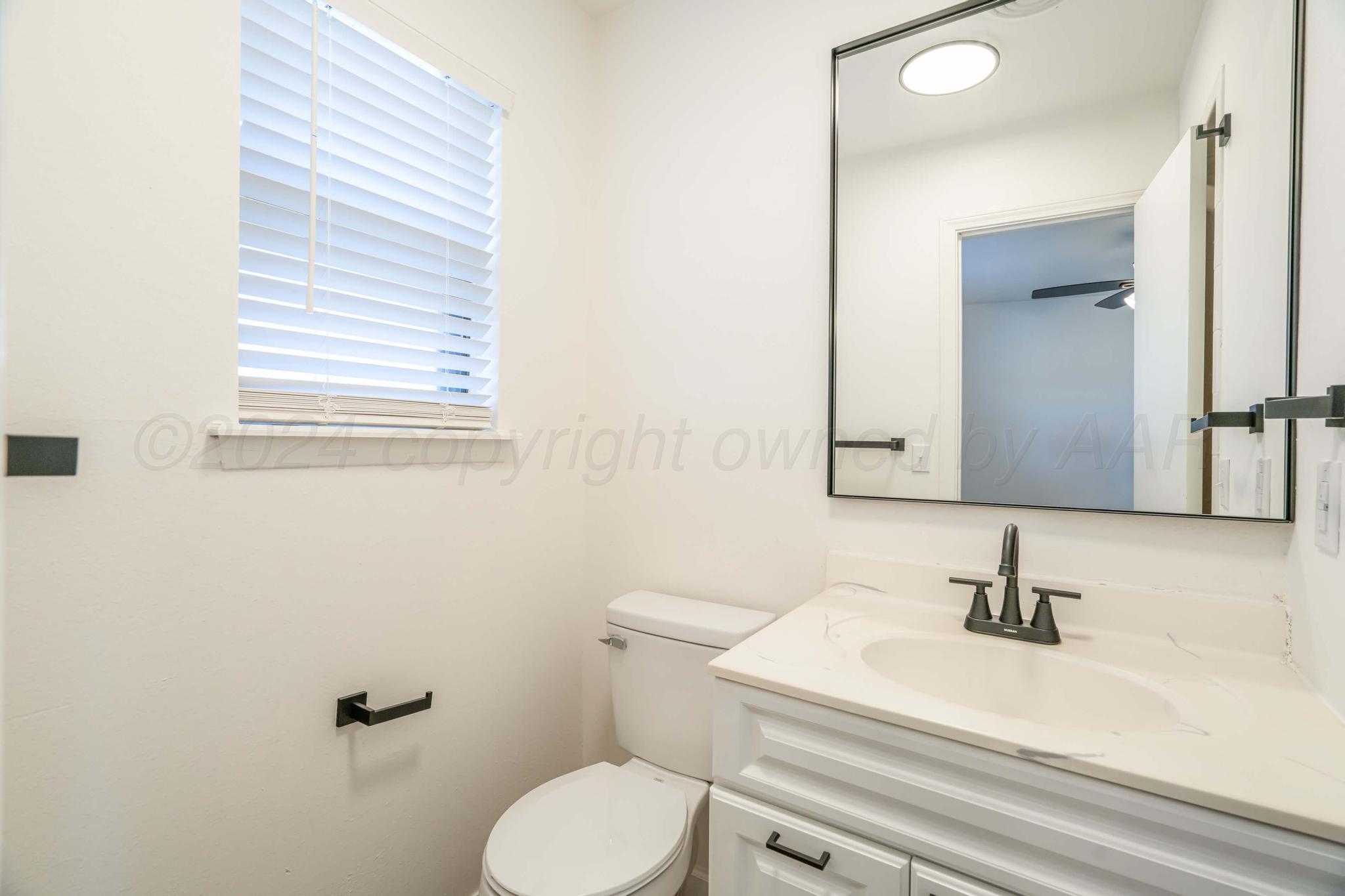 3206 Wind Song Drive Amarillo, TX 79103 - Photo 15 of 27 a bathroom with a sink a toilet and mirror