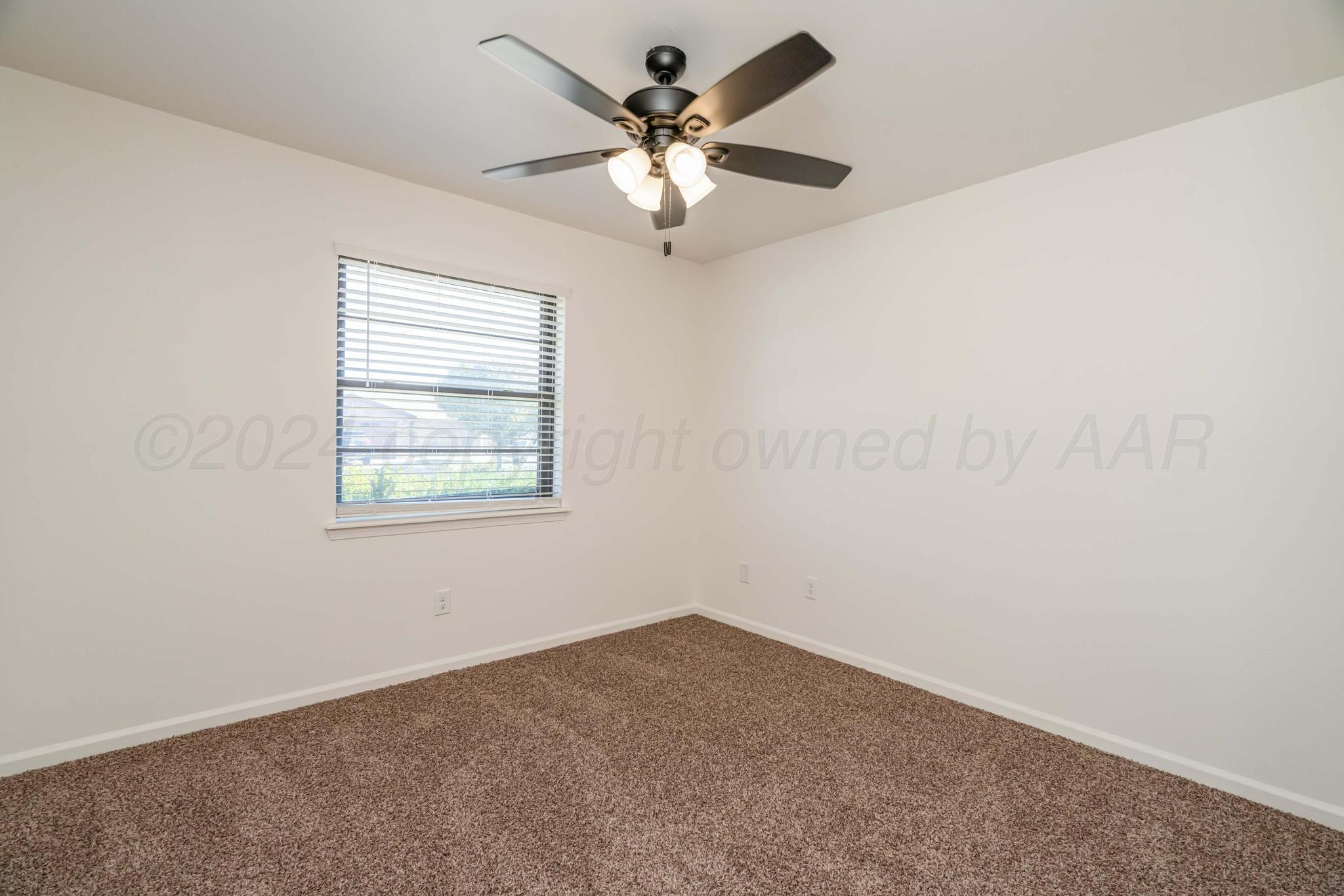 3206 Wind Song Drive Amarillo, TX 79103 - Photo 21 of 27 an empty room with a chandelier fan and windows