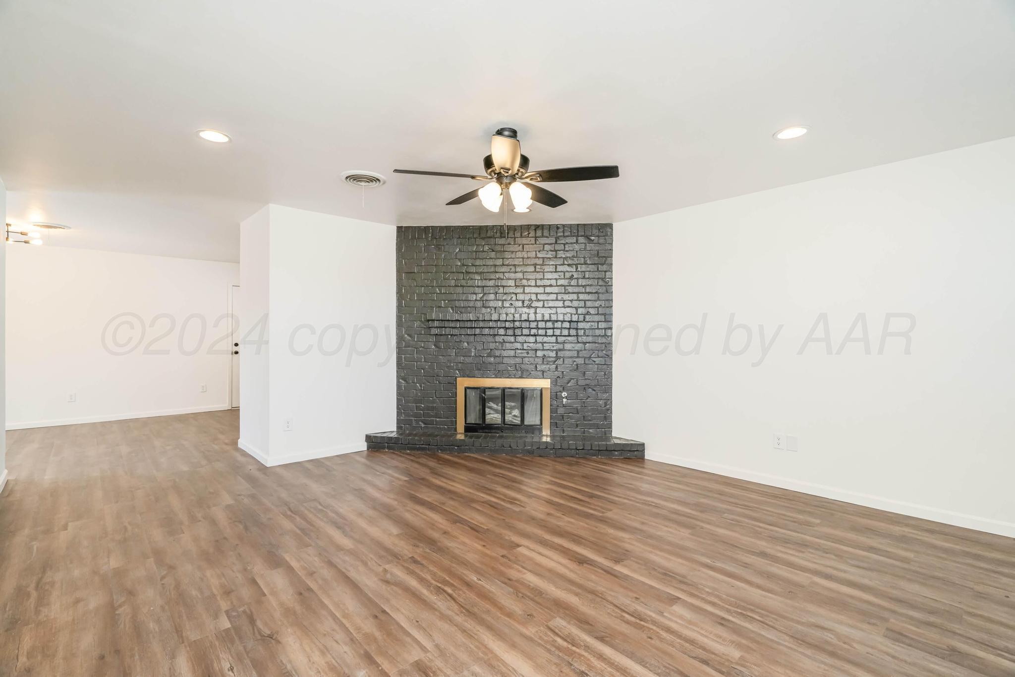 3206 Wind Song Drive Amarillo, TX 79103 - Photo 3 of 27 a view of empty room with wooden floor and fireplace