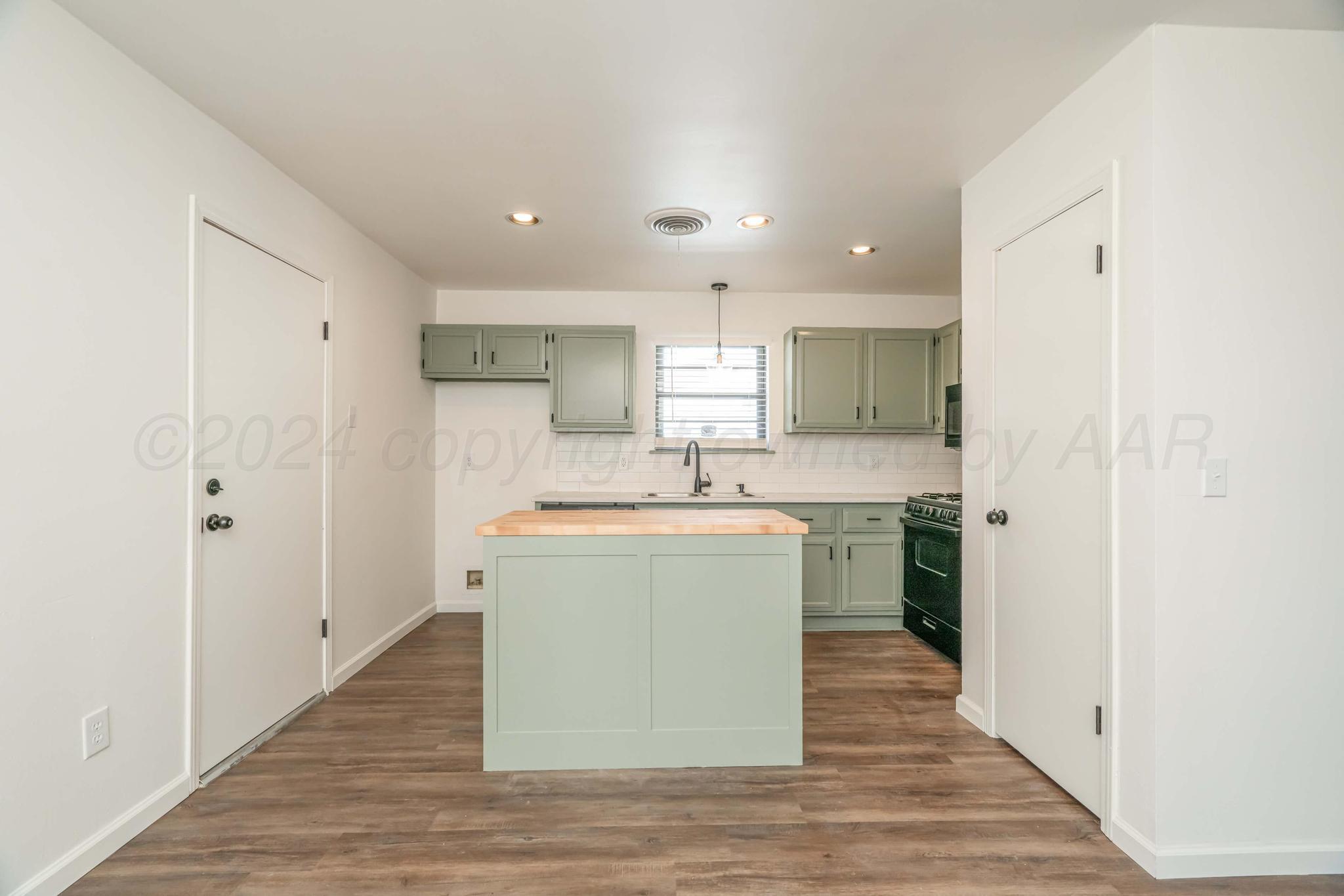3206 Wind Song Drive Amarillo, TX 79103 - Photo 7 of 27 a kitchen with a sink refrigerator and cabinets