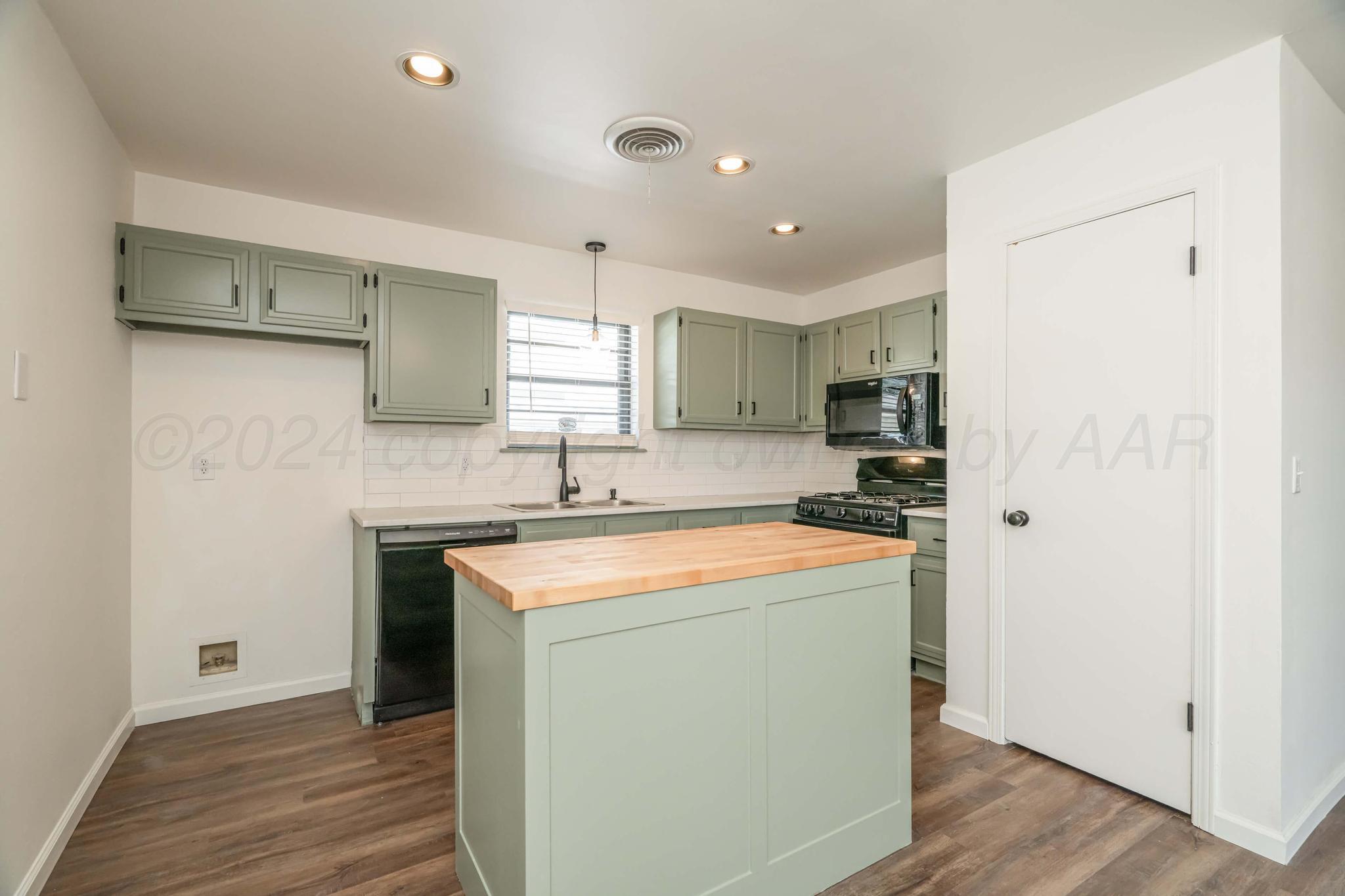 3206 Wind Song Drive Amarillo, TX 79103 - Photo 8 of 27 a kitchen with stainless steel appliances granite countertop a sink a stove a refrigerator and island with wooden floor