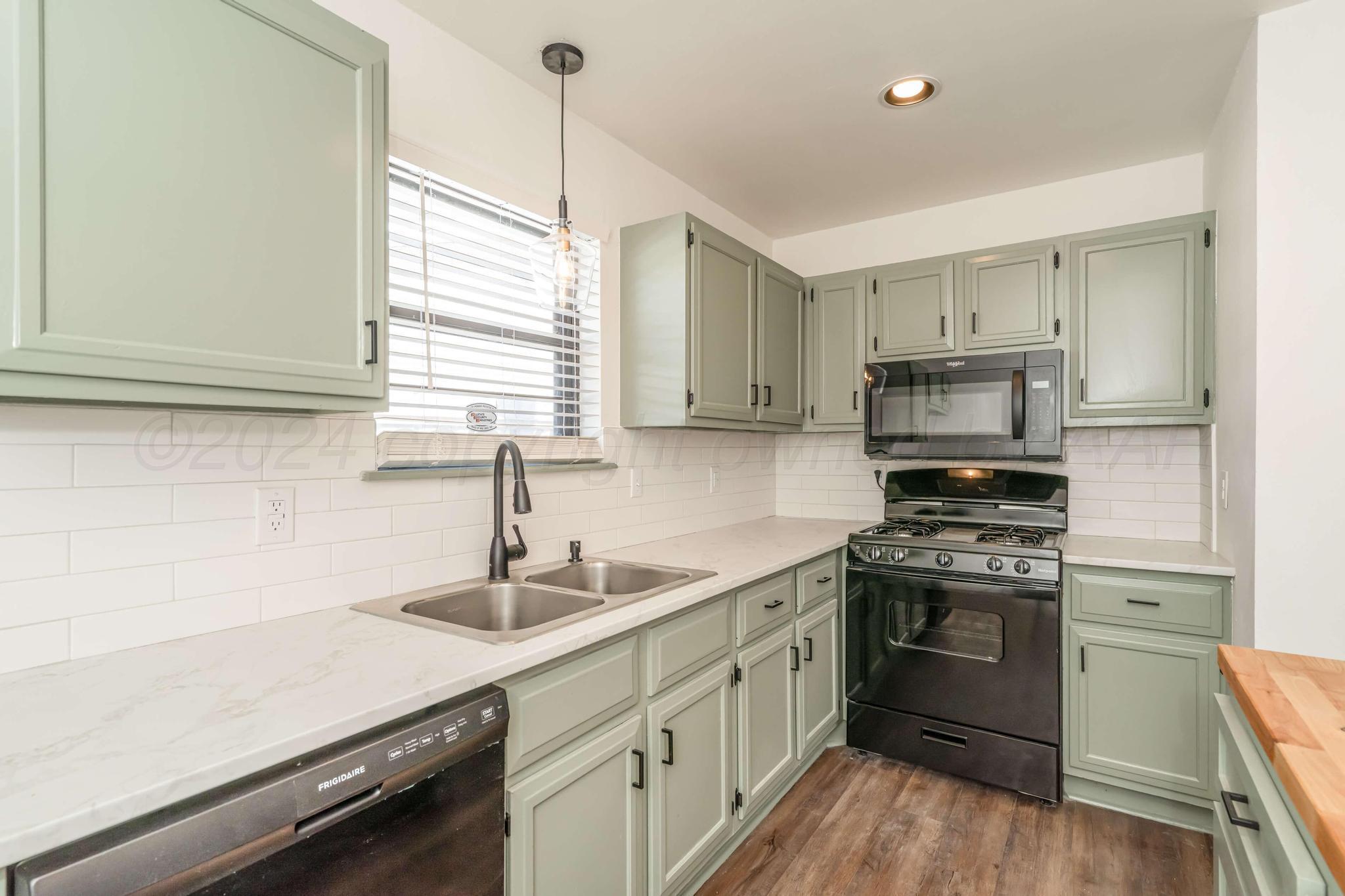 3206 Wind Song Drive Amarillo, TX 79103 - Photo 9 of 27 a kitchen with white cabinets appliances and a window