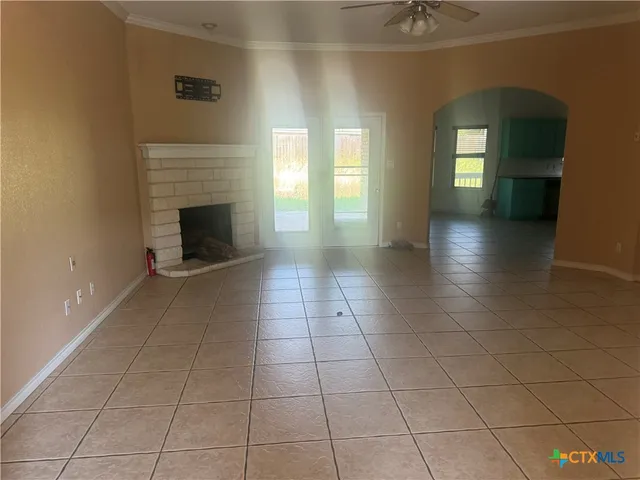 a view of an empty room with a fireplace and a window