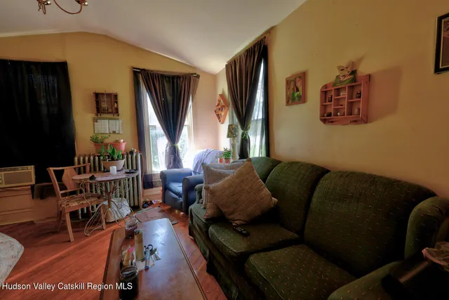a view of empty room with window and wooden floor