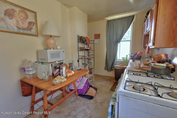 a view of an empty room with chandelier and wooden floor