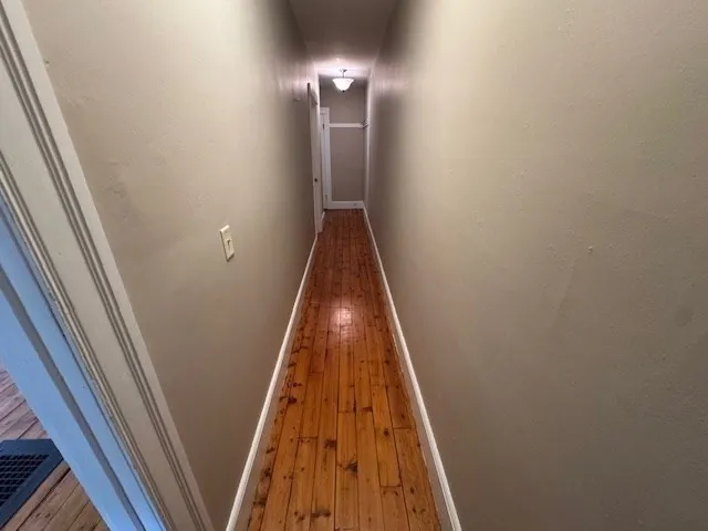 a view of empty room with wooden floor