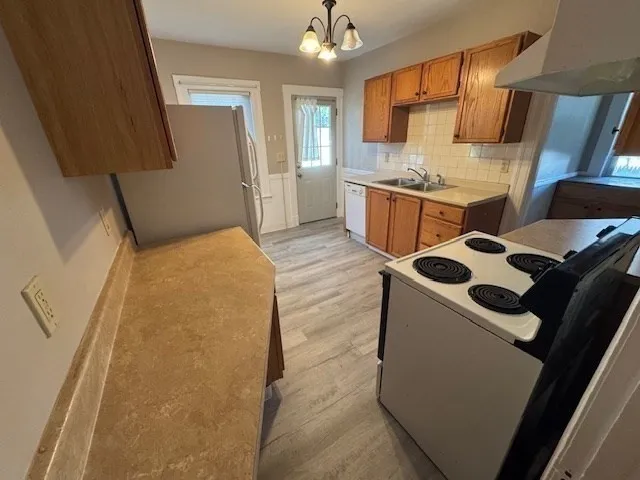 a kitchen with stainless steel appliances a stove a sink and a refrigerator