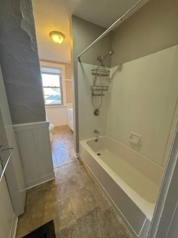 a bathroom with a tub shower vanity and a sink
