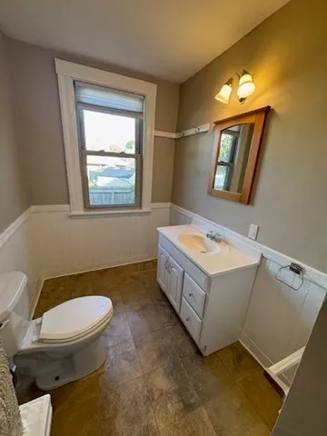 a bathroom with a tub a toilet a sink and mirror