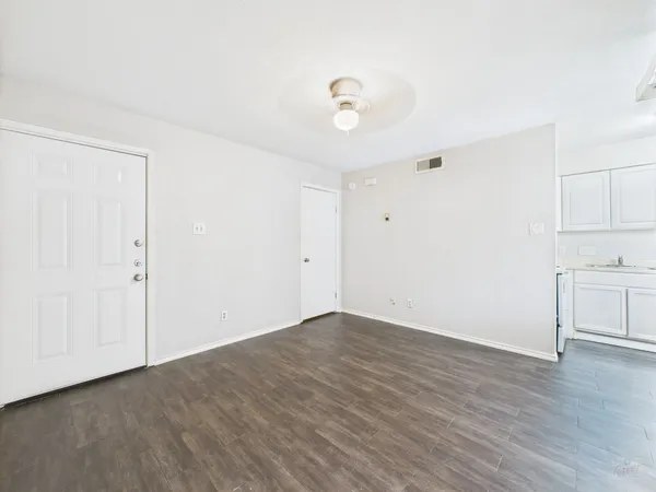 a view of a kitchen with wooden floor and a window