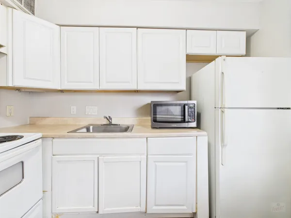 a kitchen with a sink a stove a refrigerator and cabinets