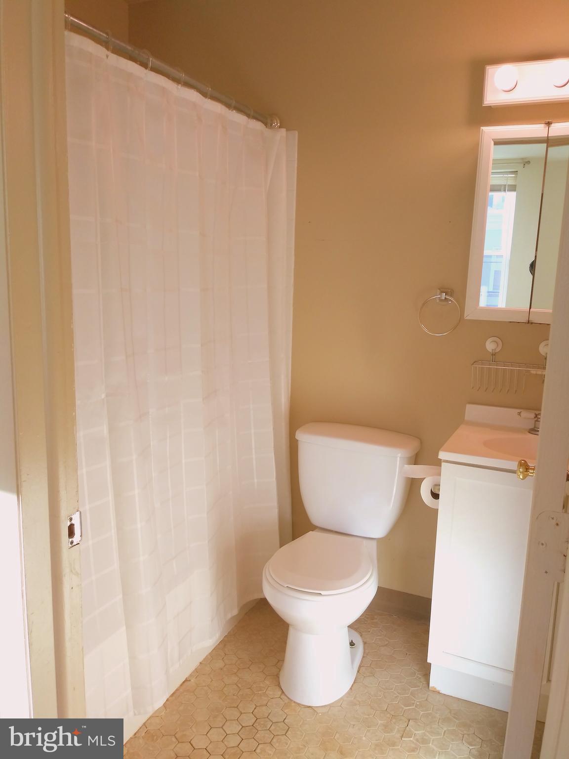 715 South 23rd Street, Unit 1F Philadelphia, PA 19146 - Photo 11 of 12 a white toilet sitting next to a white sink and vanity