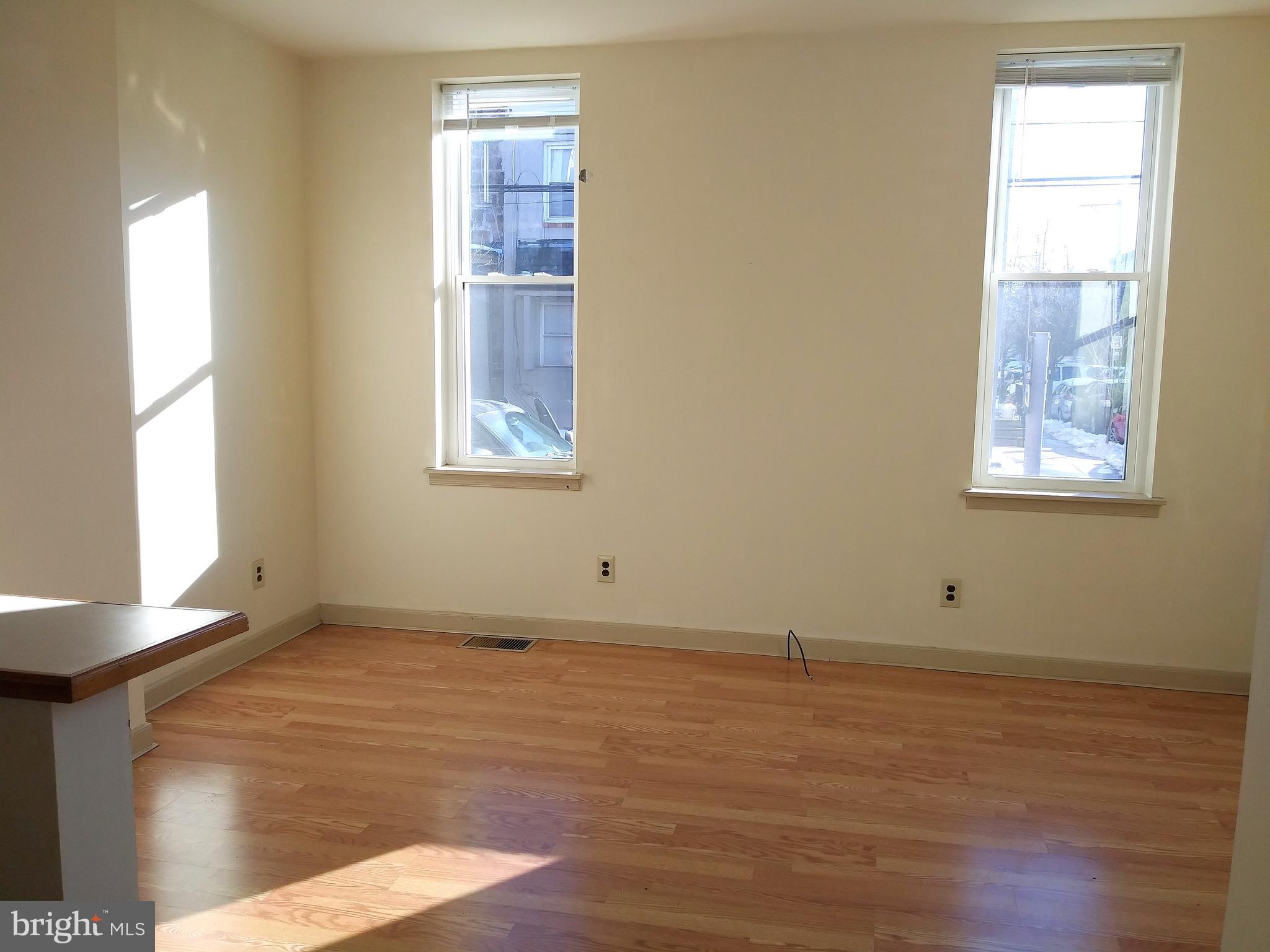 715 South 23rd Street, Unit 1F Philadelphia, PA 19146 - Photo 5 of 12 a view of an empty room with wooden floor and a window