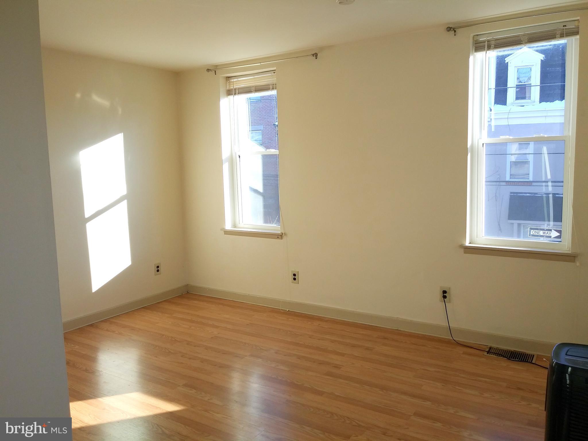 715 South 23rd Street, Unit 1F Philadelphia, PA 19146 - Photo 8 of 12 a view of an empty room with wooden floor and a window