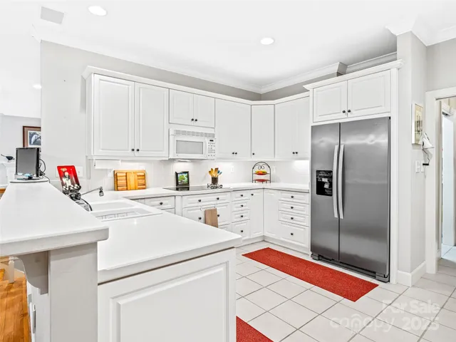 a large white kitchen with stainless steel appliances and cabinets