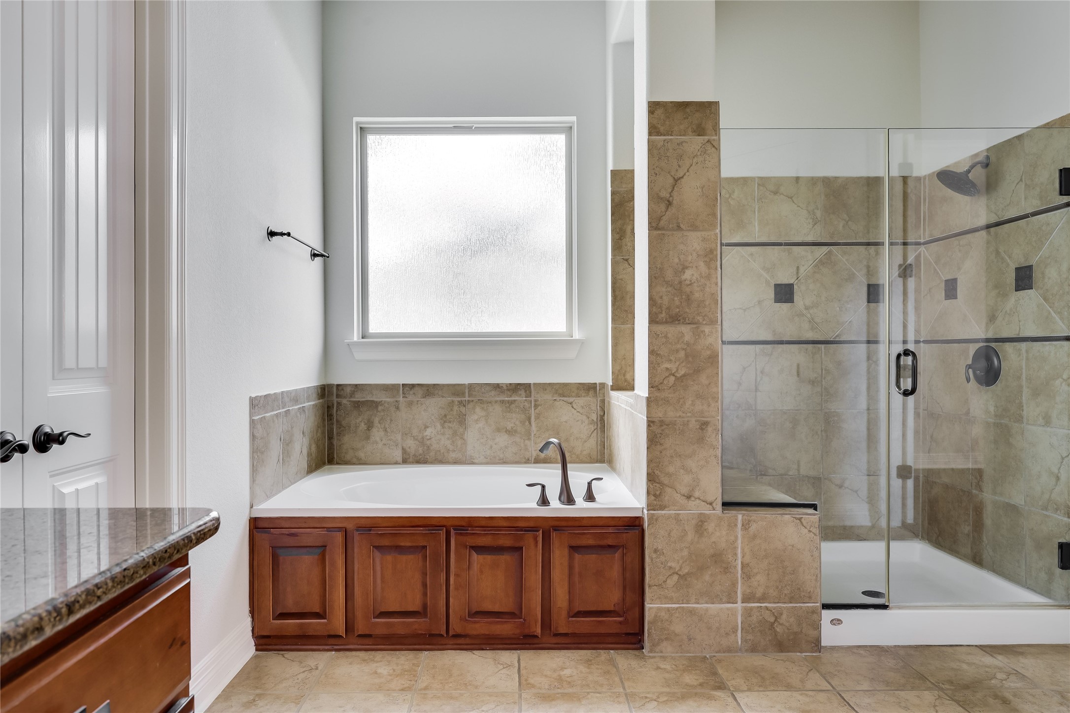 401 Bluff View Road Cedar Park, TX 78613 - Photo 35 of 40 Discover a tranquil primary bathroom featuring a spacious built-in tub and an enclosed glass shower.