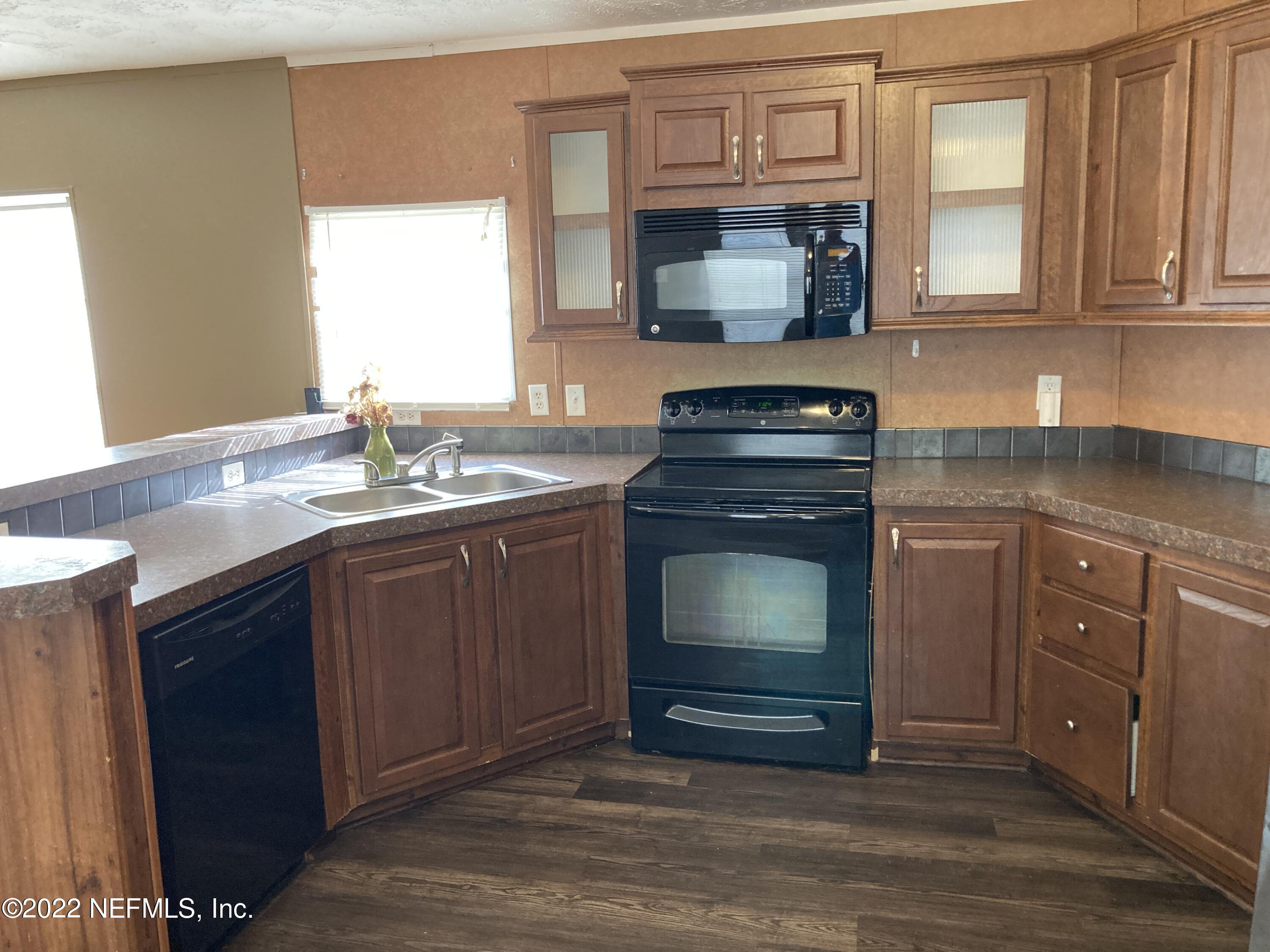 1352 Long Bay Road Middleburg, FL 32068 - Photo 2 of 13 a kitchen with stainless steel appliances granite countertop a stove microwave and sink