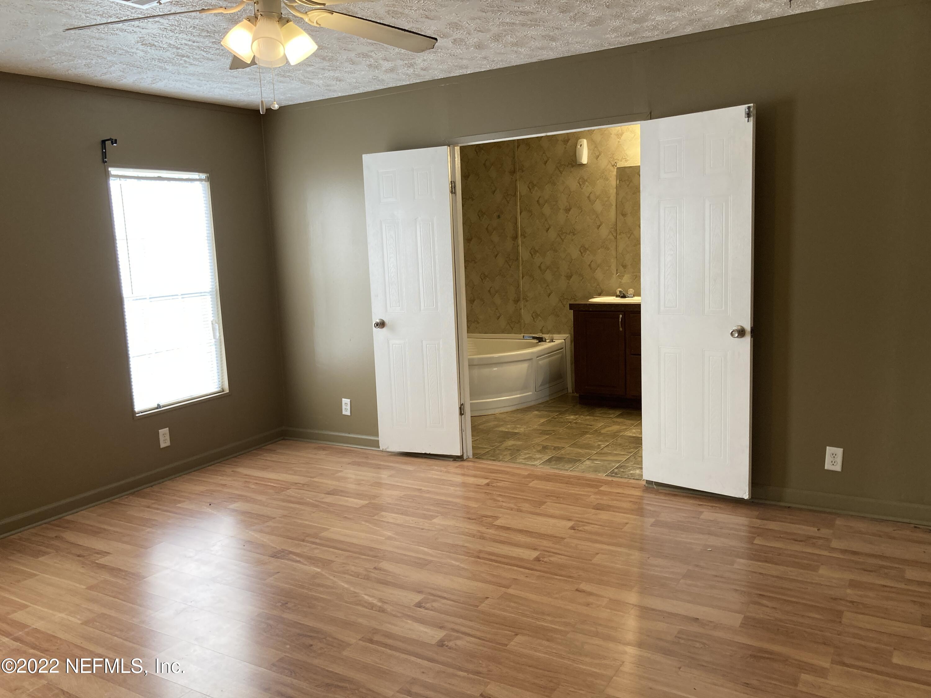 1352 Long Bay Road Middleburg, FL 32068 - Photo 8 of 13 a view of an empty room with wooden floor and a window