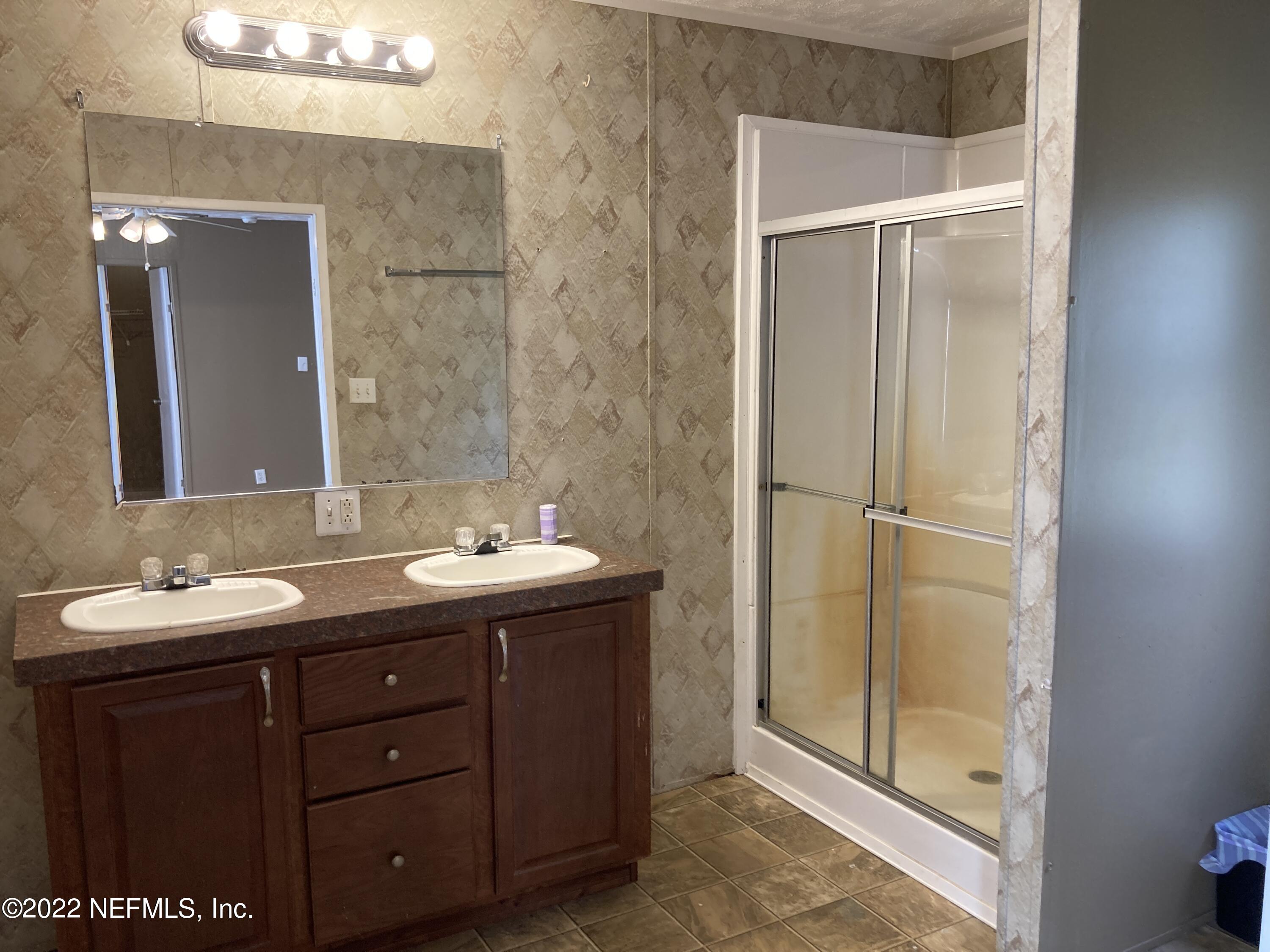 1352 Long Bay Road Middleburg, FL 32068 - Photo 10 of 13 a bathroom with a double vanity sink mirror and shower