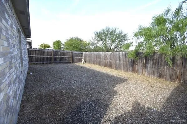 a view of a backyard with wooden fence