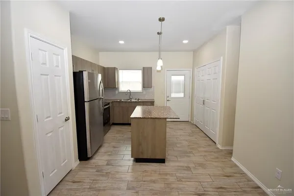 a large kitchen with a refrigerator and a sink