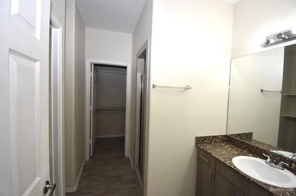 a bathroom with a granite countertop sink and a mirror
