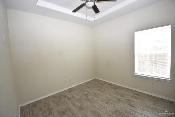 an empty room with a window and a ceiling fan