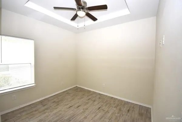 an empty room with a window and a fan