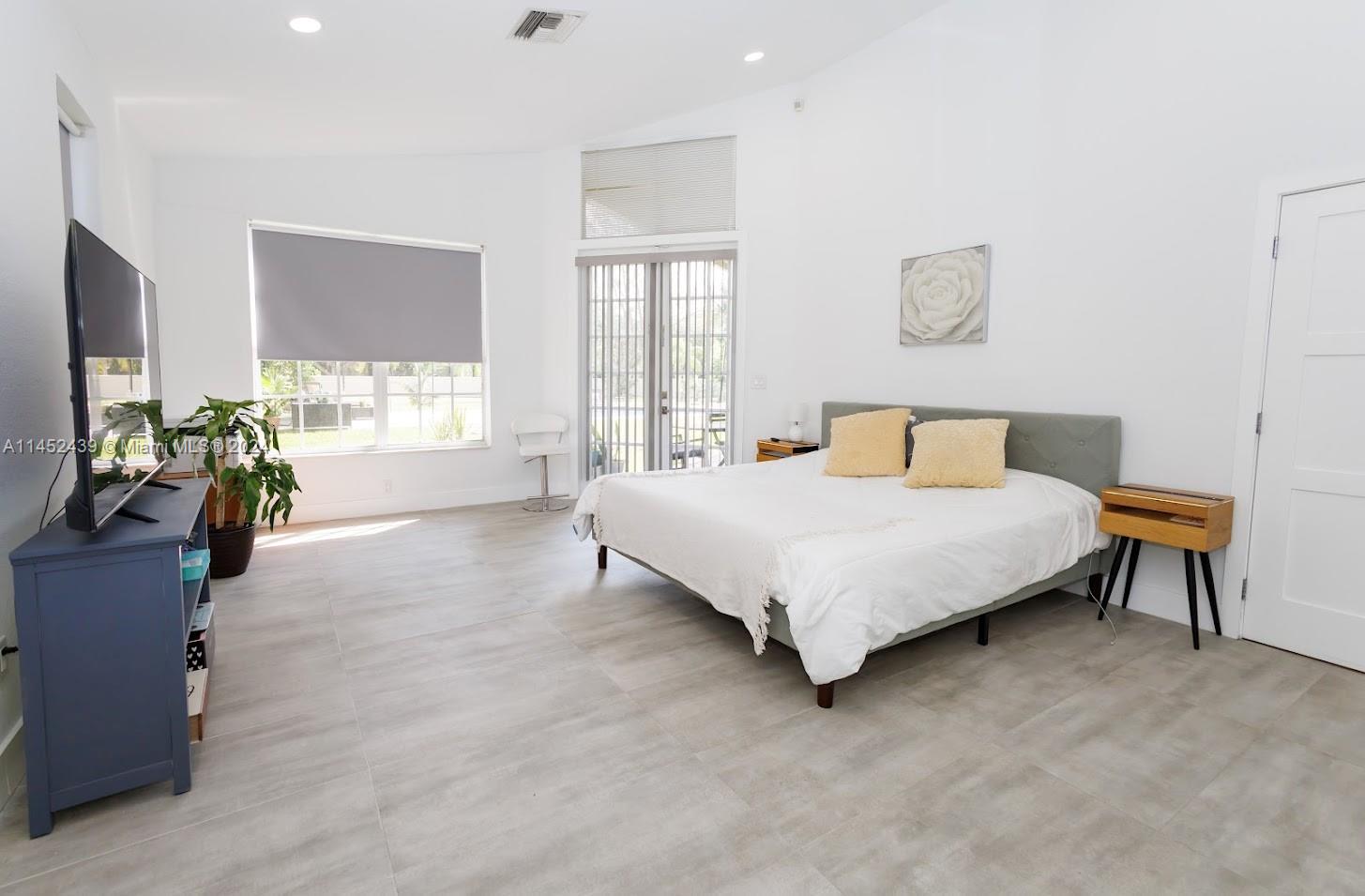 6110 Falconsgate Avenue Davie, FL 33331 - Photo 15 of 33 a bedroom with a bed and a flat tv screen on dresser