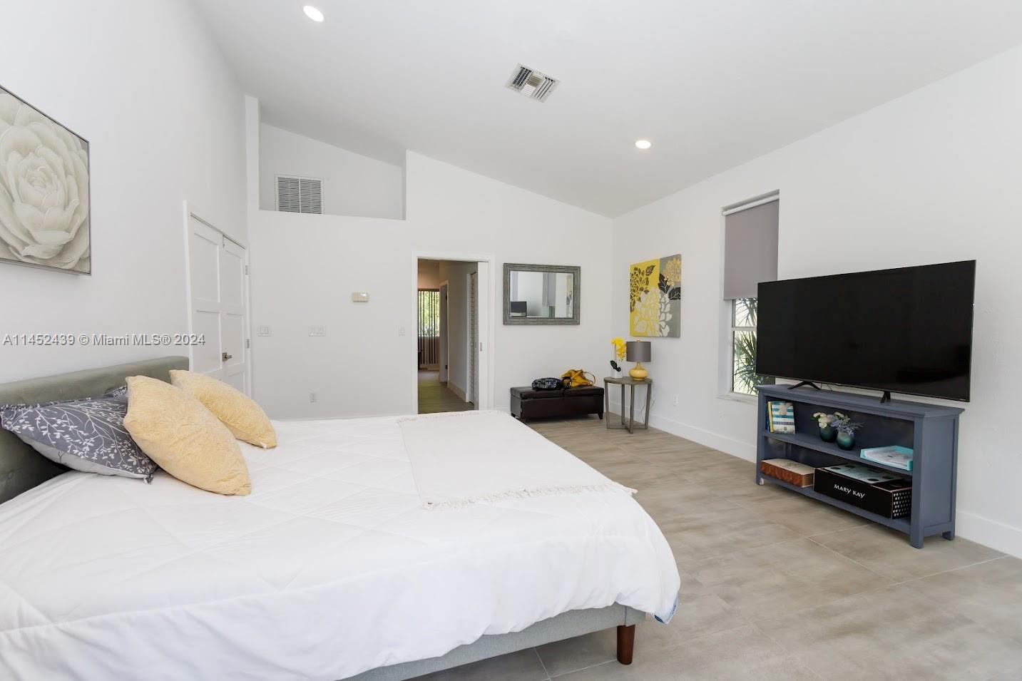 6110 Falconsgate Avenue Davie, FL 33331 - Photo 16 of 33 a bedroom with a bed and a flat screen tv