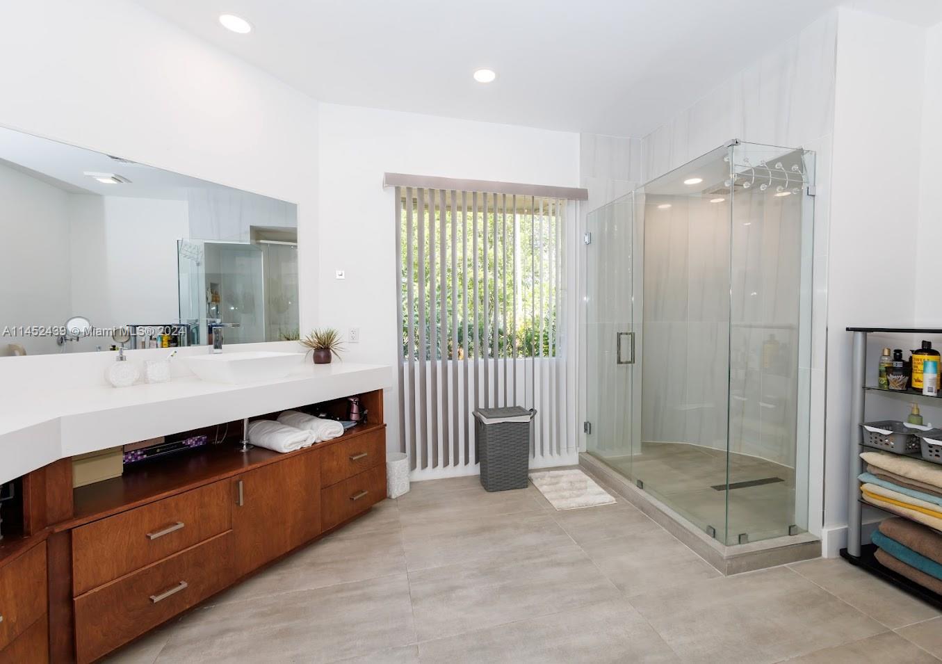 6110 Falconsgate Avenue Davie, FL 33331 - Photo 18 of 33 a spacious bathroom with a shower sink and mirror