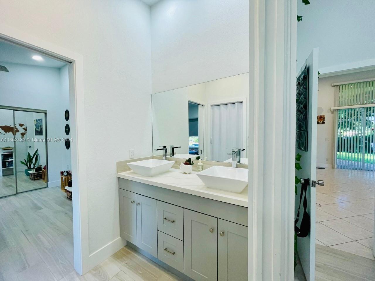 6110 Falconsgate Avenue Davie, FL 33331 - Photo 24 of 33 a bathroom with a double vanity sink and mirror