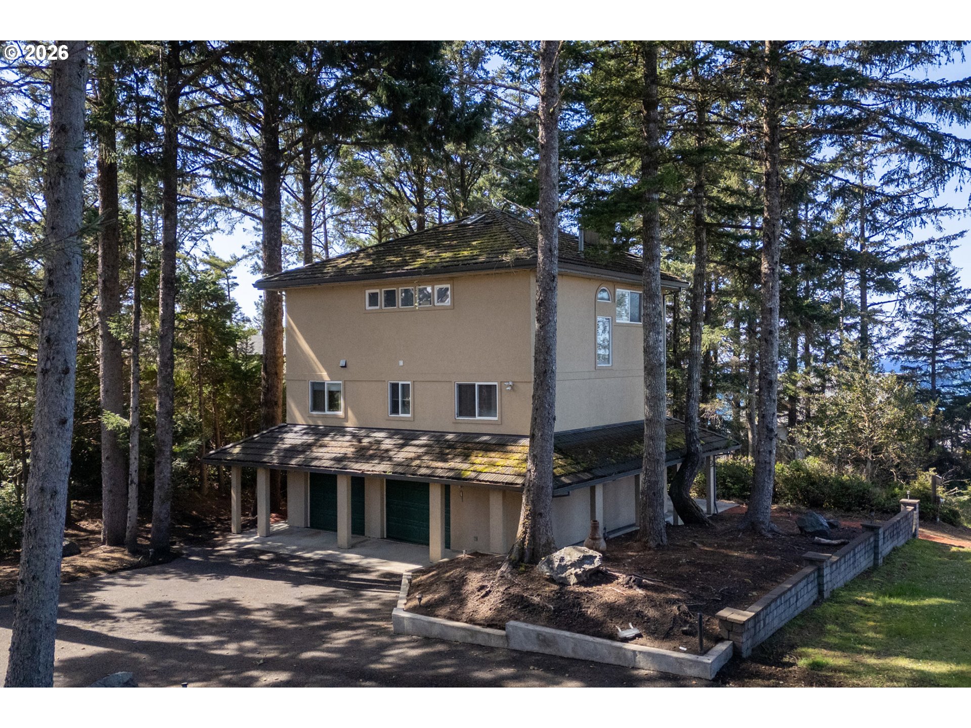 a view of house with yard outdoor seating and covered with trees in the background