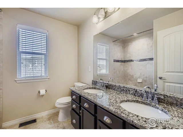 a bathroom with a granite countertop sink toilet a large mirror and shower