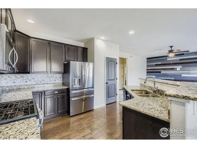 a kitchen with kitchen island granite countertop a stove and a sink