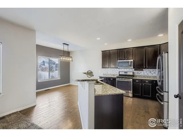 a kitchen with stainless steel appliances granite countertop a refrigerator and a stove top oven