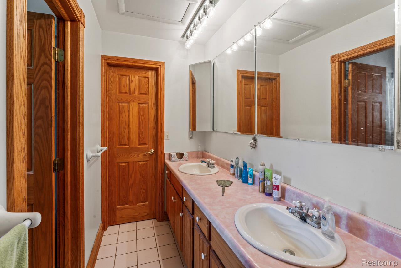 1591 Baldwin Road Lapeer, MI 48446 - Photo 22 of 46 Bathroom featuring light tile patterned flooring and double vanity