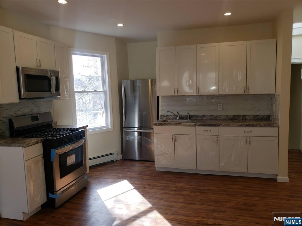 a kitchen with granite countertop a refrigerator stove and microwave