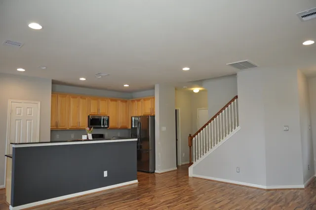 a view of a kitchen with a sink and dishwasher a refrigerator with wooden floor