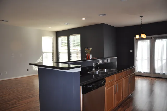 a kitchen with granite countertop a sink and a wooden floor
