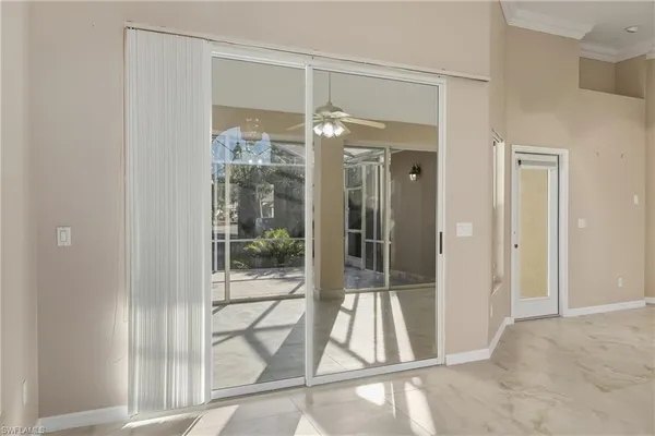 a living room with a large window and chandelier