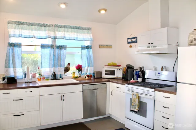 a kitchen with white cabinets and white appliances