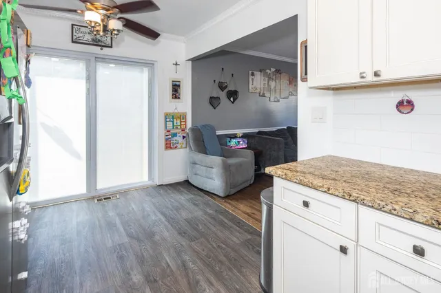 a kitchen with kitchen island granite countertop wooden cabinets and white appliances