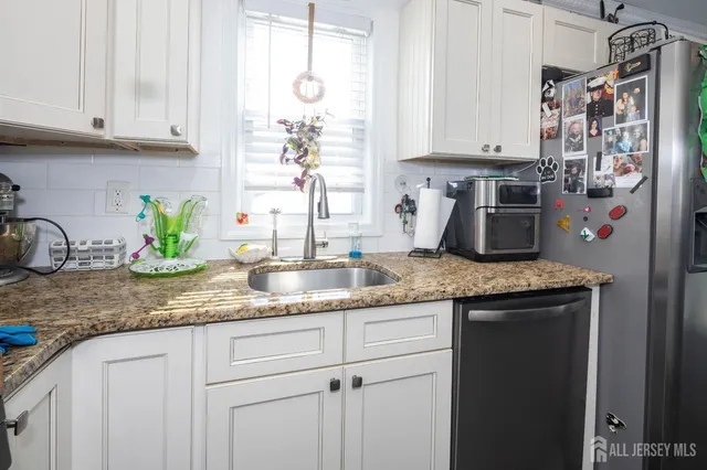 a kitchen with granite countertop a sink a stove and cabinets