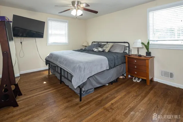 a bedroom with a bed and a flat tv screen on the dresser