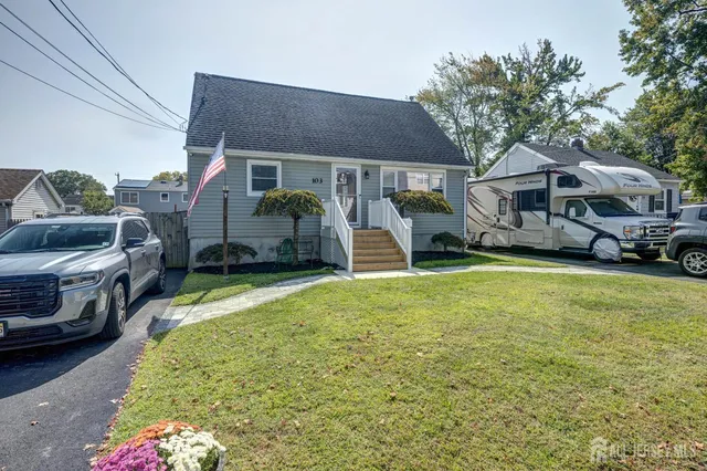 a front view of a house with a garden and trees