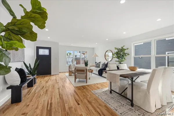 a living room with furniture flowers and wooden floor