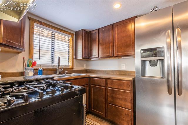 12 Cherokee Road Manitou Springs, CO 80829 - Photo 9 of 22 Kitchen with gas stove and under counter lighting.